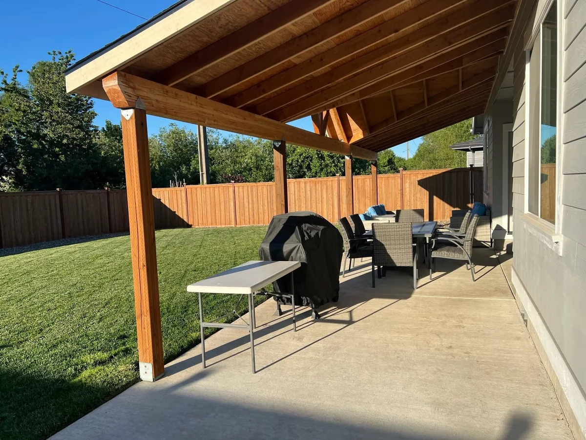 A spacious outdoor area showcasing a grill, patio cover, cozy seating, and a lush lawn. The setup is perfect for barbecues, sunset dinners, and outdoor games, encouraging guests to enjoy open-air fun and meals together.