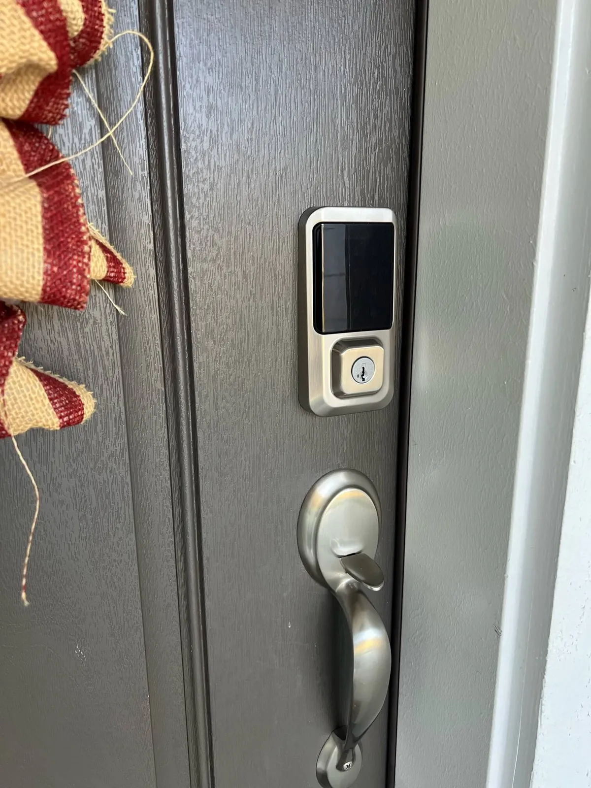 A close-up of a digital lock on a stylish door, adorned with a decorative wreath. This image captures the advanced keyless entry feature and a welcoming entrance vibe.